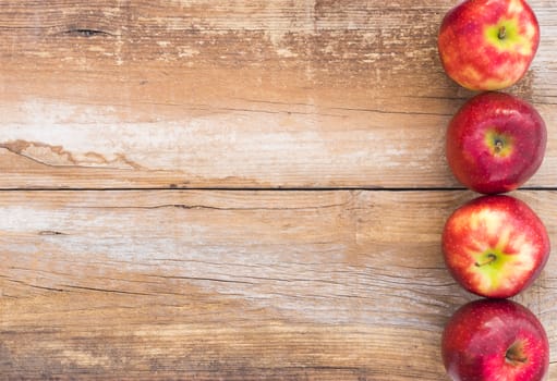 Apples background with fresh red fruits on wooden table 