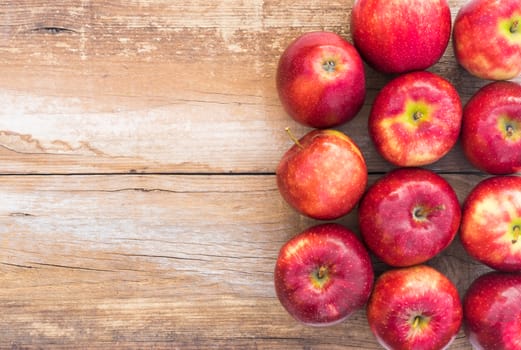 Apples background with juicy red fruits on wooden table