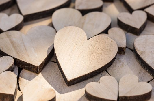 Romantic love background with close-up of many wooden hearts