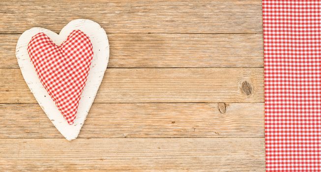 Romantic red fabric heart on wooden background with copy space