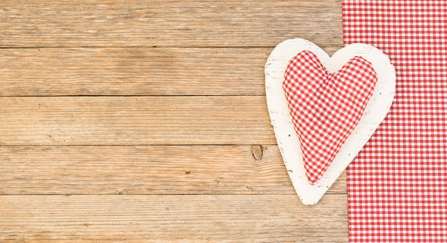 Rustic red fabric heart on wooden background with copy space