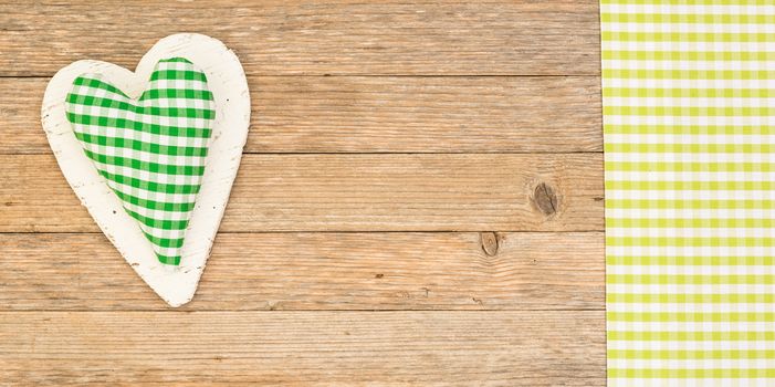 Green heart on wooden background with copy space