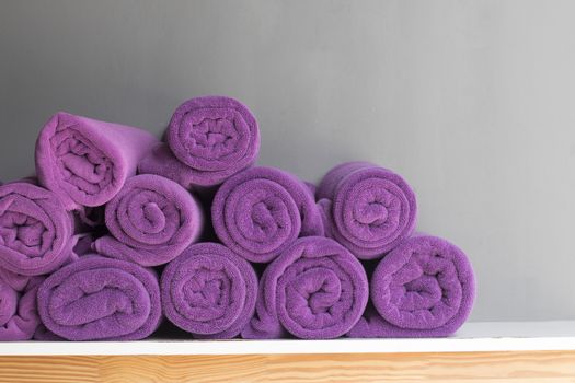 Purple towels rolled on top of the table.