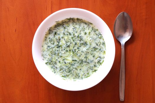 cucumber sour milk soup on a wooden table, top view