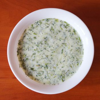cucumber sour milk soup on a wooden table, top view