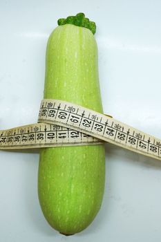 soft measuring linear zucchini wrapped around as a symbol of healthy eating