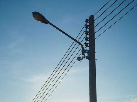 High voltage light poles with street lights attached On a background that is sky With the sun shining in the morning.
Energy concept.