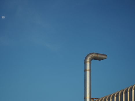 Stainless steel chimney on a blue sky background.
Concept of environmental protection.