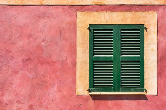 Green wooden window shutters of mediterranean house