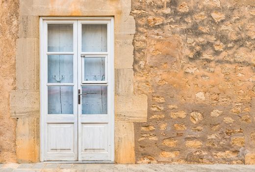 White front door and stone wall of mediterranean house