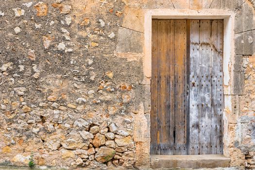 Detail view of ancient gray wooden door and rustic stone wall background
