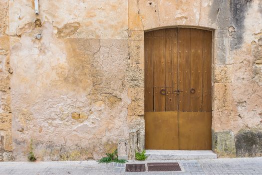 Close-up of old brown wooden front door and facade wall background