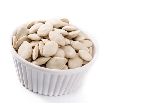 Pumpkin seeds in bowl isolated on white background