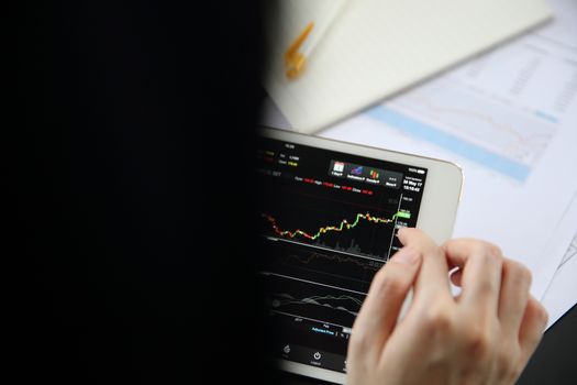 Woman hand Trading online on tablet with business paper and coffee