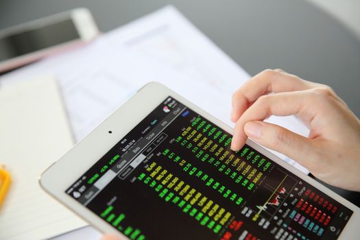 Woman hand Trading online on tablet with business paper and coffee