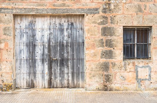 Vintage gate with rustic old stone wall
