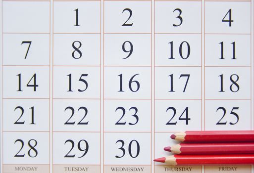 calendar and three red pencils near the last date. planning concept