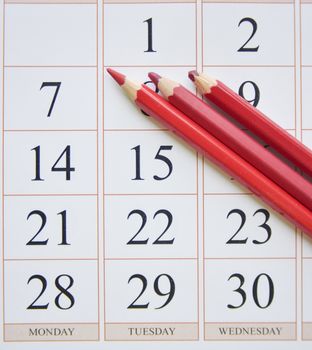 calendar and three red pencils near the last date. planning concept