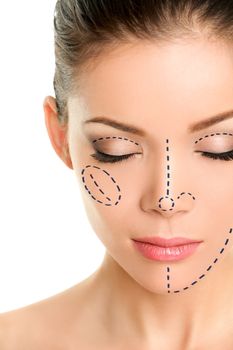 Plastic surgery lines on Asian woman face. Closeup of female adult with closed eyes with pencil marks on skin for cosmetic medical procedures. Surgical mark lines on eyes, nose, cheek, and jaw.