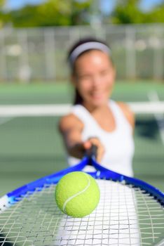 Tennis. Woman tennis player showing ball and racket on tennis court outside. Female tennis player.