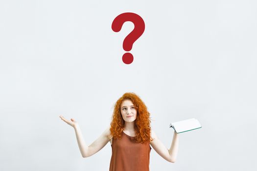 A Studio portrait of a sweet, puzzled, indecisive young woman shrugs, not understanding what happened. A rather attractive woman doubts in on a white background