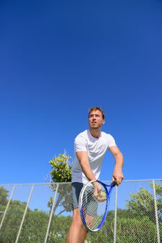 Tennis serve - man tennis player serving playing tennis outside in summer. Fit male athlete practicing. Healthy active sport lifestyle.