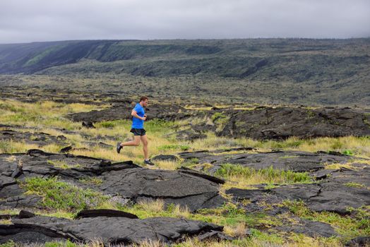 Runner. Sport running man in cross country trail run. Male athlete exercising and training outdoors in beautiful mountain nature landscape.