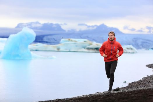 Running man. Trail runner training for marathon run in beautiful nature landscape. Fit male athlete jogging and cross country running by icebergs in Jokulsarlon glacial lake in Iceland.