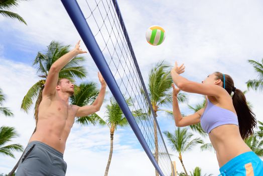 Friends playing beach volleyball sport. Woman and man having fun recreational volley ball game in summer living healthy active sport lifestyle.