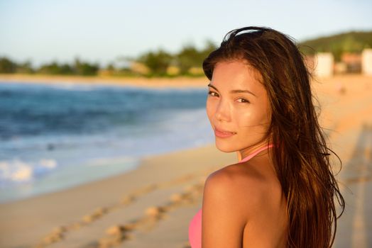 Portrait of beautiful mixed race woman on beach looking at camera. Multicultural Asian Caucasian female in bikini on North Shore of Oahu, Hawaii, USA.