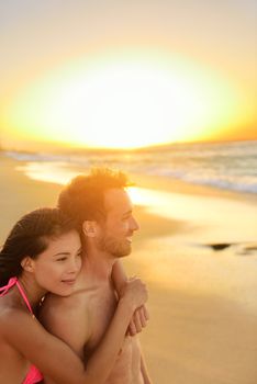 Happy romantic couple lovers on beach honeymoon having playful fun together during summer beach holidays. Cheerful young multiracial couple, Asian woman and Caucasian man. From Oahu, Hawaii, USA.