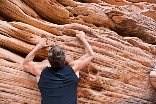 Climber man free climbing on rock. Male athlete on climb.