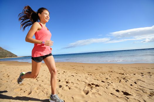 Sports athlete runner running woman on beach sweating and jogging. Fit exercising female fitness model in workout training outdoors. Biracial Asian Caucasian sports girl.