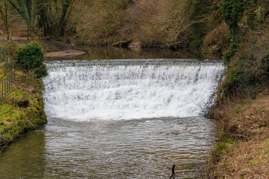 water flowing over a shallow waterfall in a river