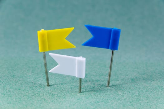 Yellow, Blue and White flag pins on a green background