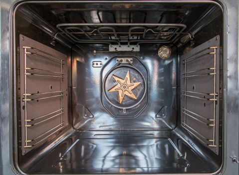 Old discoloured fan exposed in oven after cover removed and showing heating element