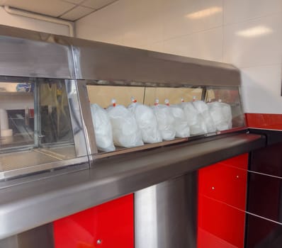 Bags containing prawn Crackers in a chinese takeaway warmer