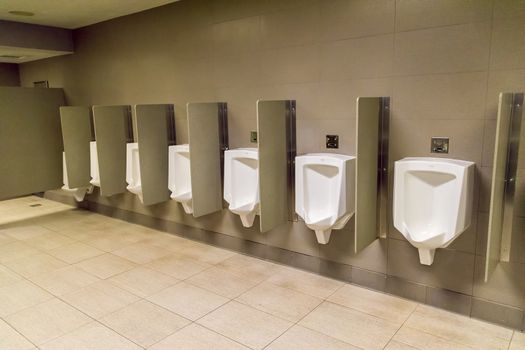 Row of mens urinals on a wall