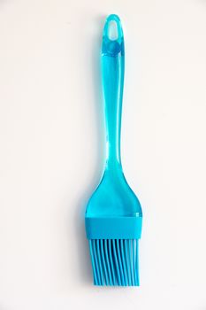 Blue plastic and silicon basting brush on a white background