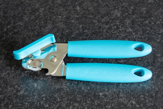 Blue coloured can opener on a dark background