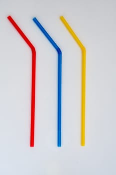 Three different coloured plastic drinking straws