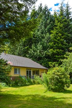 Frontage of a nice house among trees. Front side of a house on country side in British Columbia, Canada