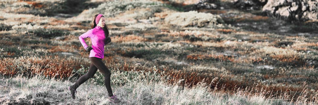 Running woman in winter trail mountain banner background. Runner athlete training cardio in cold weather outdoors. Asian girl wearing warm leggings and pink clothing.