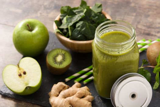 Healthy green smoothie in jar on wooden table