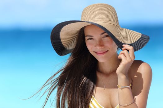 Asian woman wearing fashion straw beach hat for skin care sun protection. Face skincare beauty concept. Beautiful Chinese Caucasian mixed race young adult girl portrait on summer vacation travel.