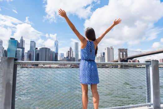 Happy free woman cheering at NYC New York city urban skyline with arms up raised in the sky. Success in business career, goal achievement or carefree freedom successful urban person concept.