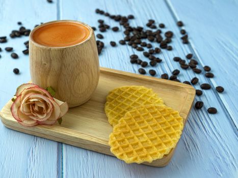 Warm offee in a brown bamboo cup with waffles and brown sugar.