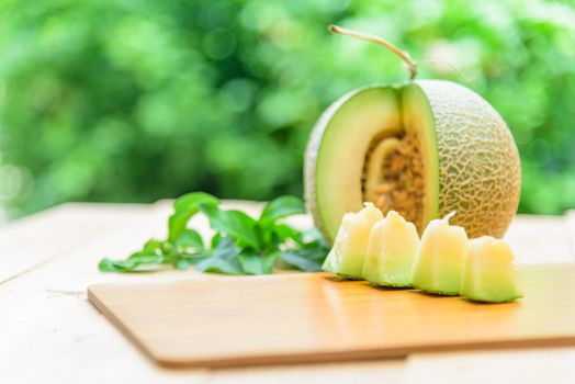 Fresh green melon on wood plate