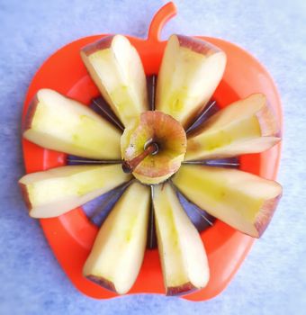 Apple shown beautifully in apple cutter like flower shape and it tempts to eat in white background