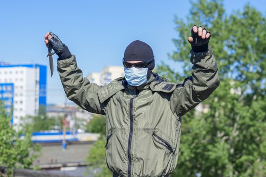 Criminal surrenders to law enforcement by raising his hands up and throwing a knife to the ground